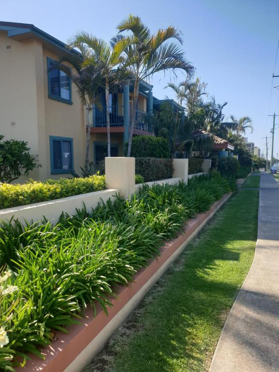 una fila de plantas delante de una casa en Oxley Cove Holiday Apartment, en Port Macquarie