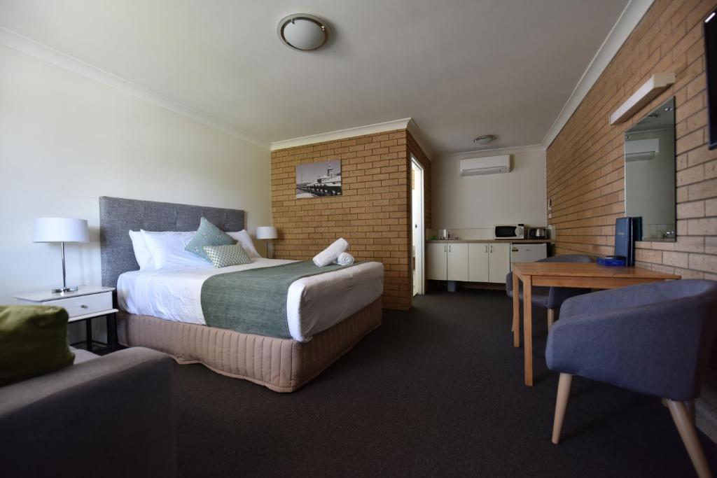 a hotel room with a bed and a couch at Albury Allawa Motor Inn in Albury