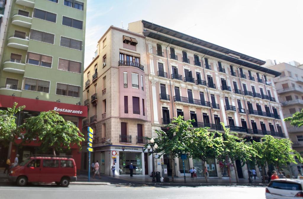 uma carrinha vermelha estacionada em frente a um edifício em Apartamentos Boni em Alicante