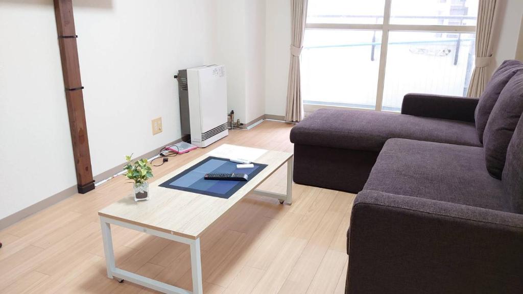 sala de estar con sofá y mesa de centro en すすきの駅から徒歩9分 アクセス便利 Shimaya Building 605 島屋ビル, en Sapporo