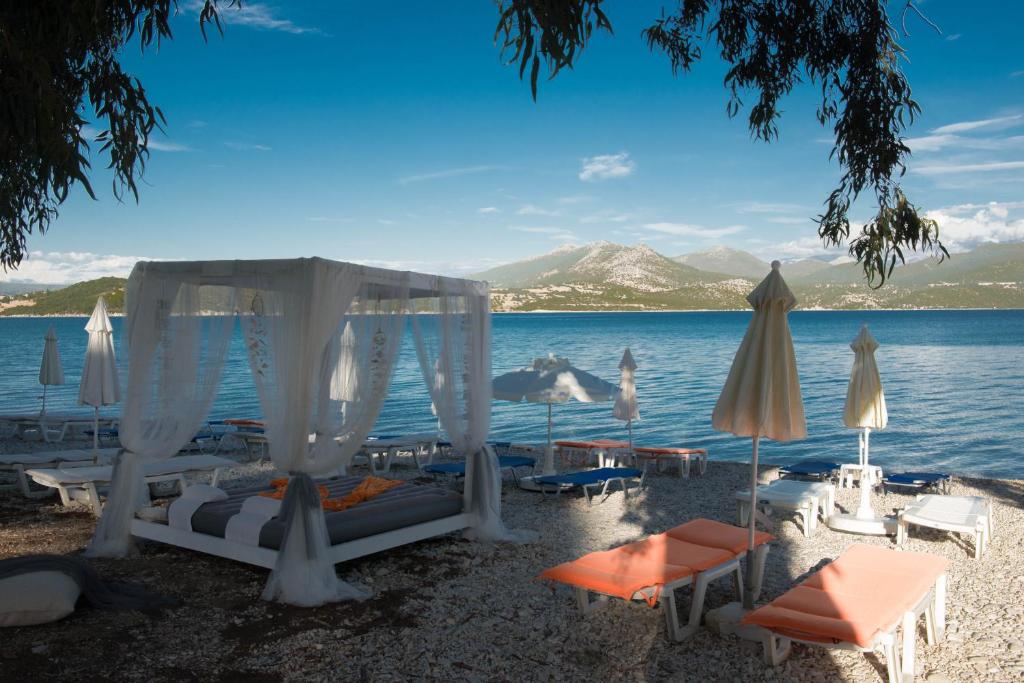 a group of beds and umbrellas on a beach at Mavra Studios in Lygia