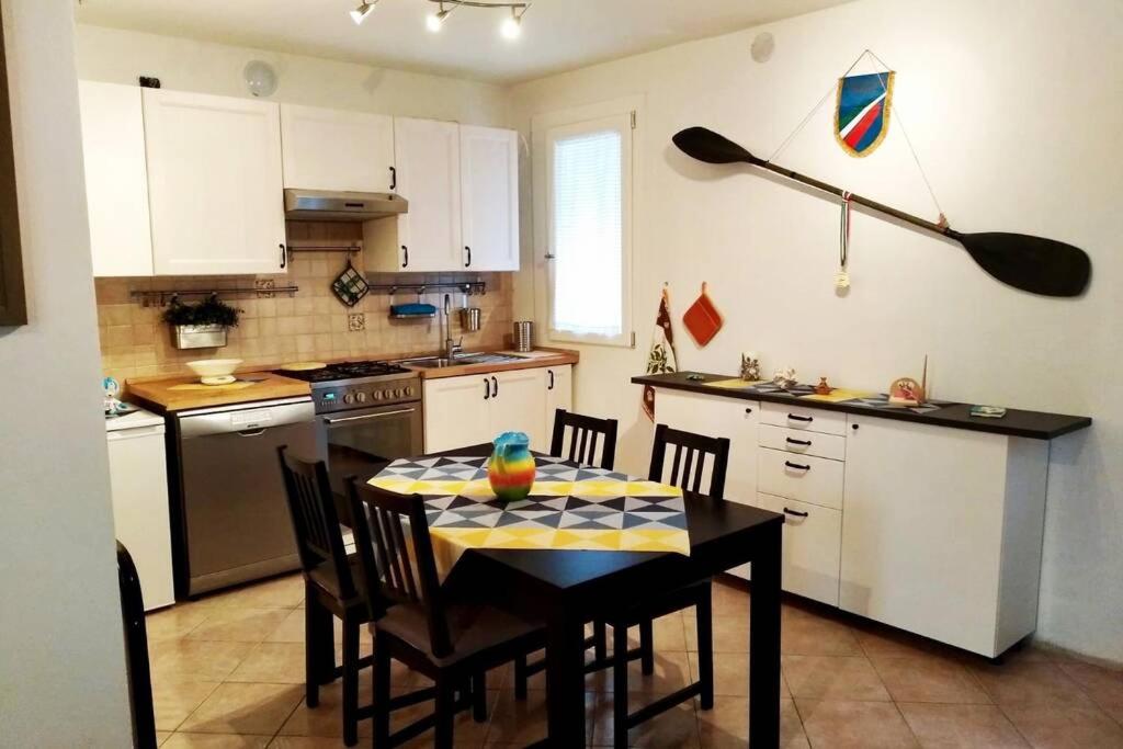 a kitchen with a table and chairs and a kitchen with a paddle at Ca'Noa in Valstagna