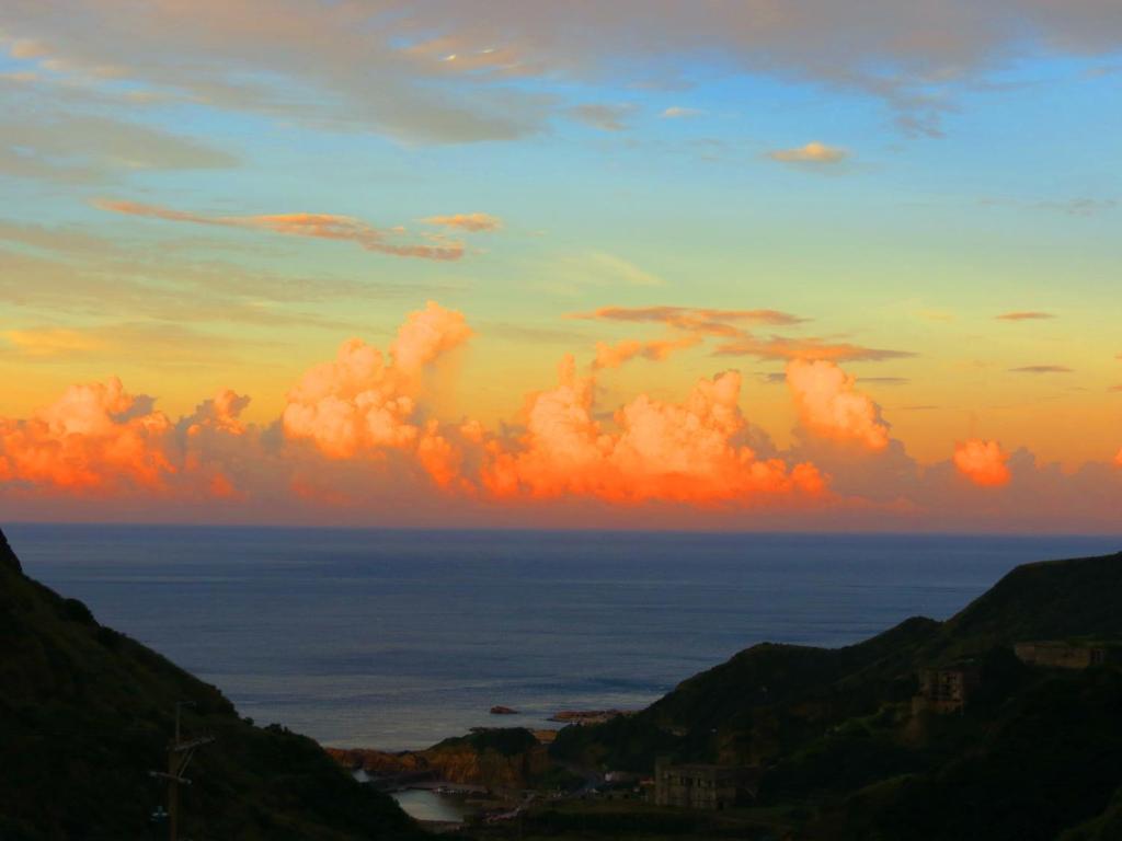 a sunset over the ocean with clouds in the sky at Formosa Arcadian Villa in Jiufen