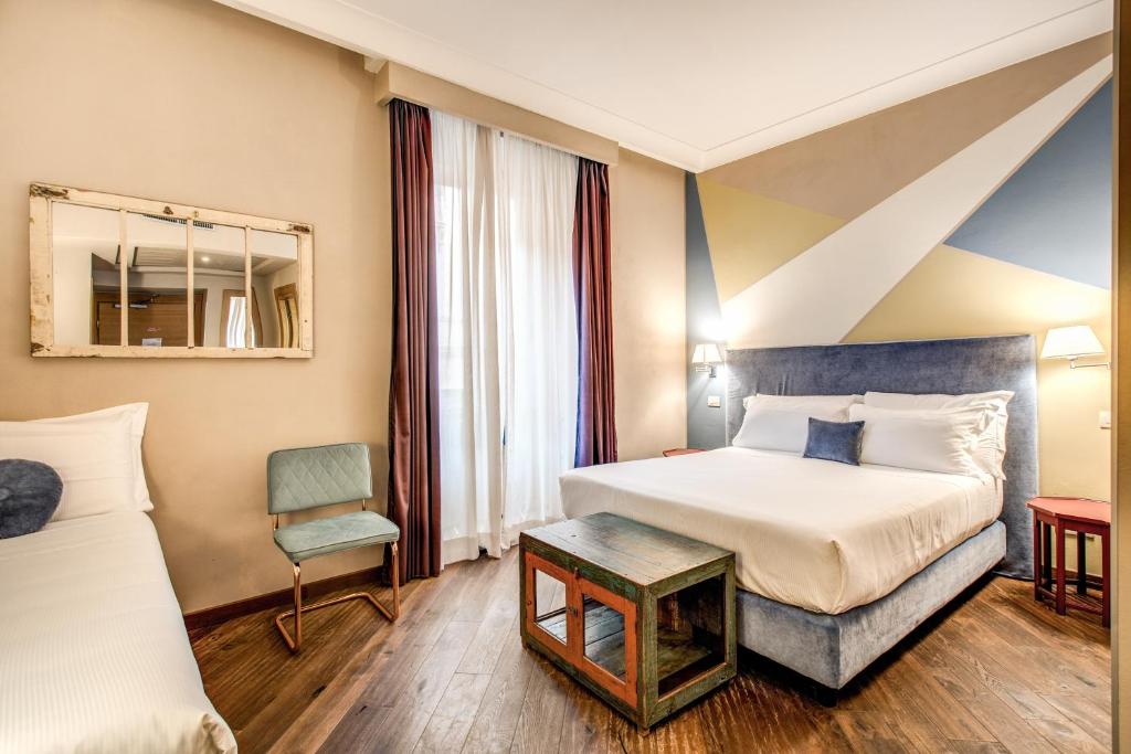 a hotel room with a bed, desk, chair and a lamp at Boutique Hotel Galatea in Rome