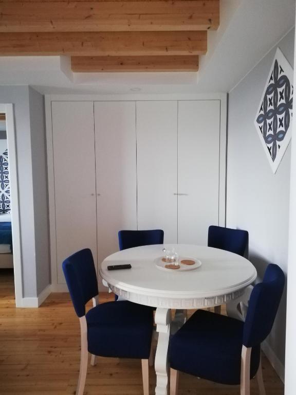 a dining room with a white table and blue chairs at Chalet O Amorzinho Sintra Praia in Sintra