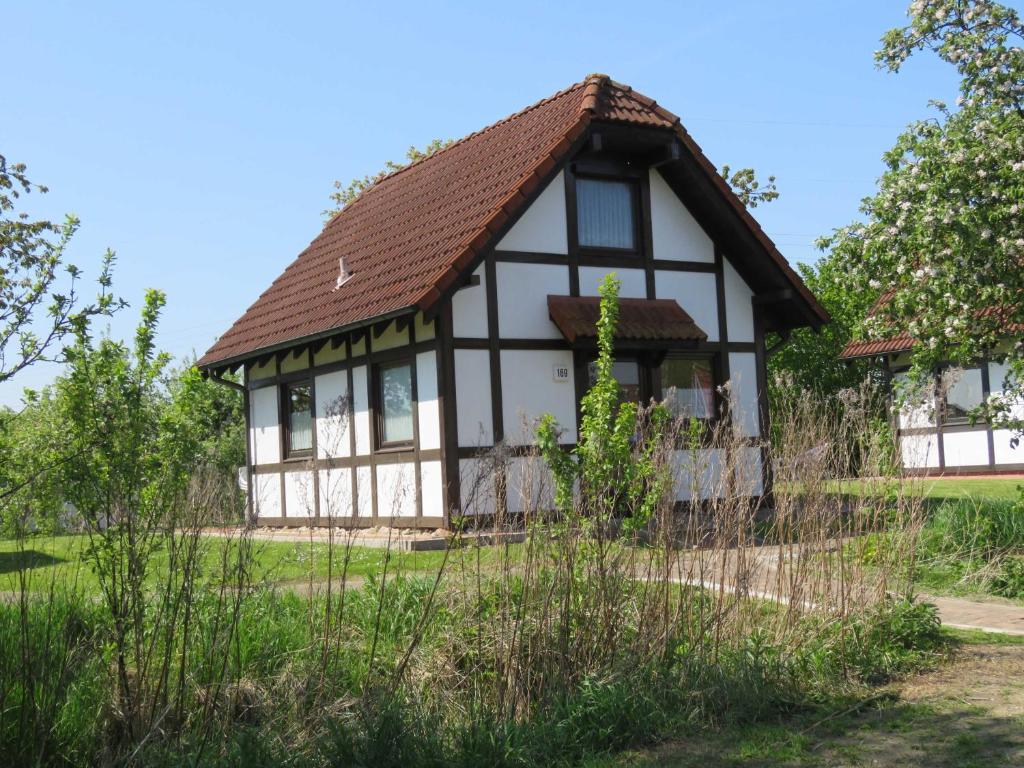 a black and white house with a brown roof at Ferienhaus Deichgraf 65 im Feriend in Hollern-Twielenfleth
