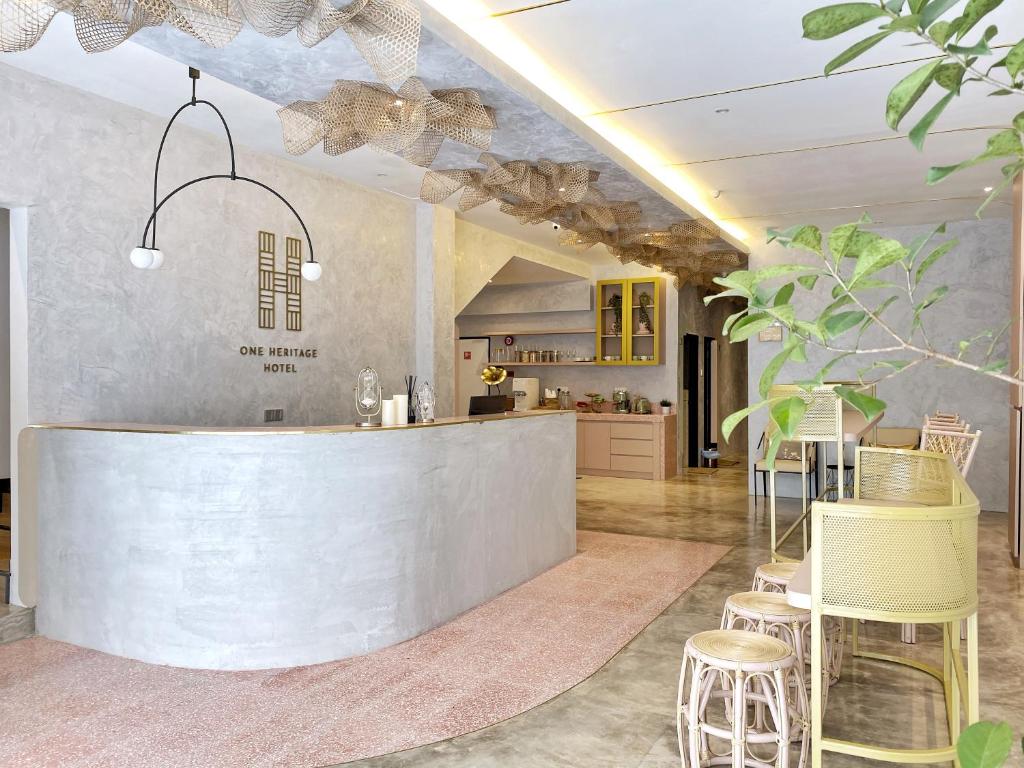 a lobby with a counter and chairs in a room at One Heritage Hotel in Seremban