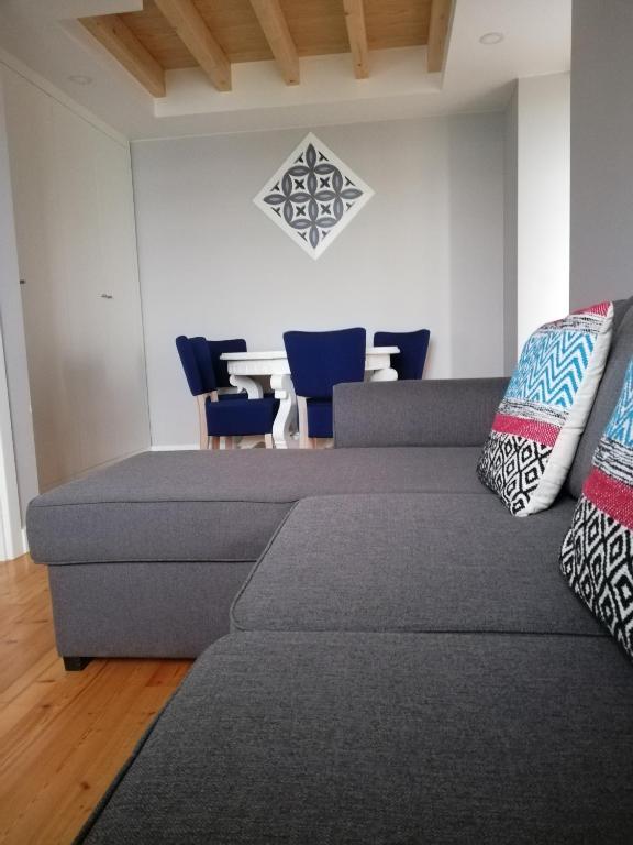 a living room with a couch and a dining room at Chalet O Amorzinho Sintra Praia in Sintra