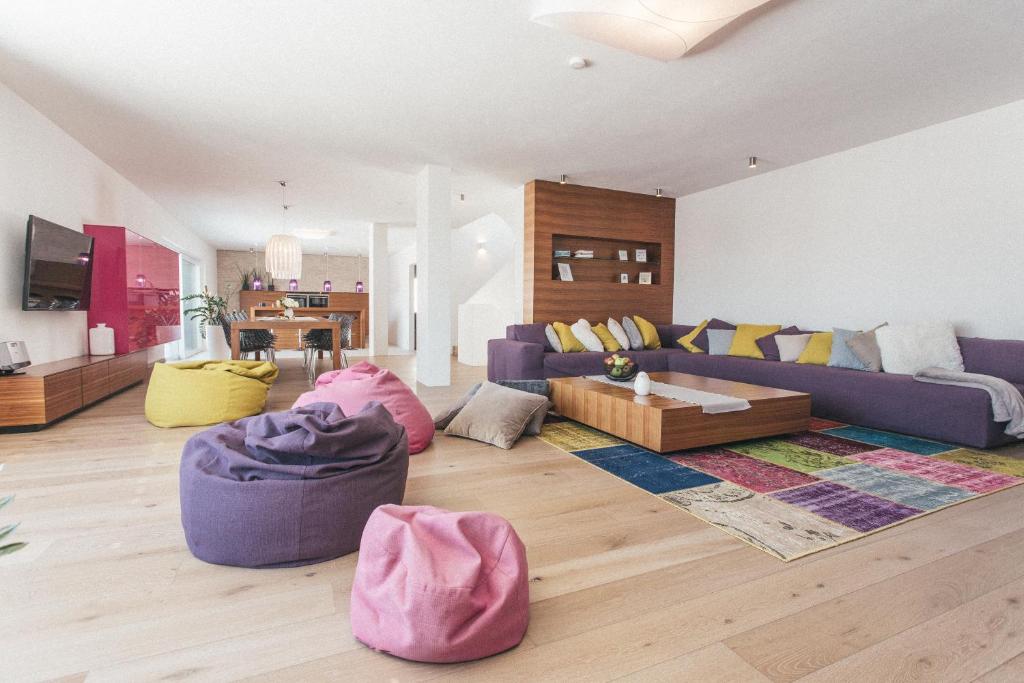 a living room with a purple couch and pillows at Glücksthaler by AA Holiday Homes - SchladmingDachstein in Aich