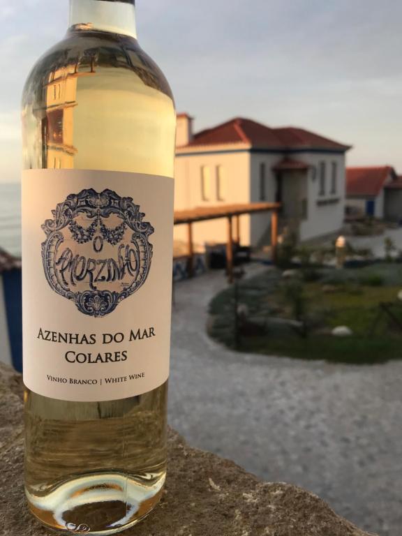 a bottle of wine sitting on top of a wall at Chalet O Amorzinho Sintra Praia in Sintra