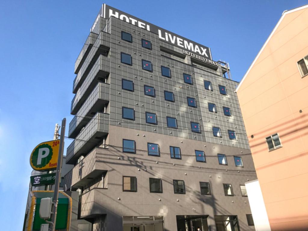 een gebouw met een bord aan de zijkant bij HOTEL LiVEMAX Okayama West in Okayama