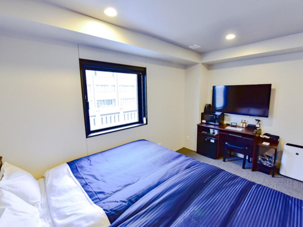 Postel nebo postele na pokoji v ubytování HOTEL LiVEMAX Okayama West