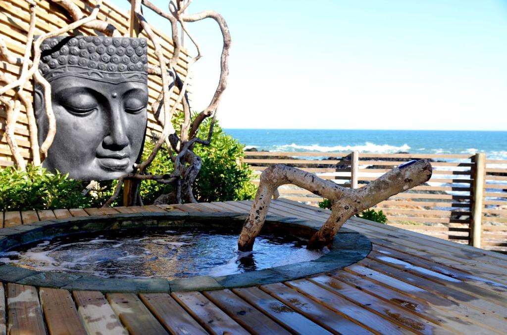 une statue d'une tête assise au-dessus d'une table en bois dans l'établissement Hotel 8 al Mar, à Pichilemu
