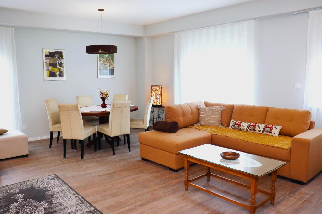 een woonkamer met een bank en een tafel bij Foxxy Luxury Apartments in Skopje