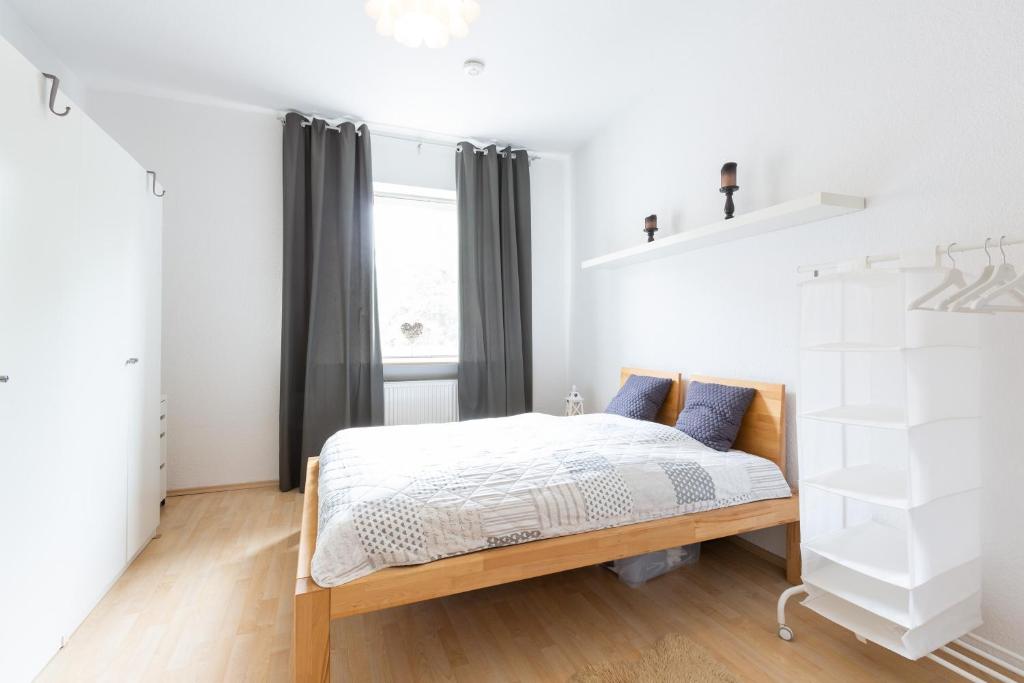 a white bedroom with a bed and a window at Deutsche Messe Zimmer - Private Apartments Hannover Exhibition Center (room agency) in Hannover