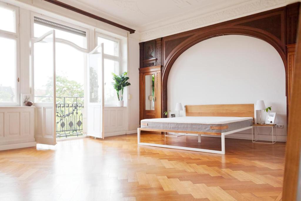 a bedroom with a bed and a large window at Green Residence Boutique Lofts & Villa in Offenbach