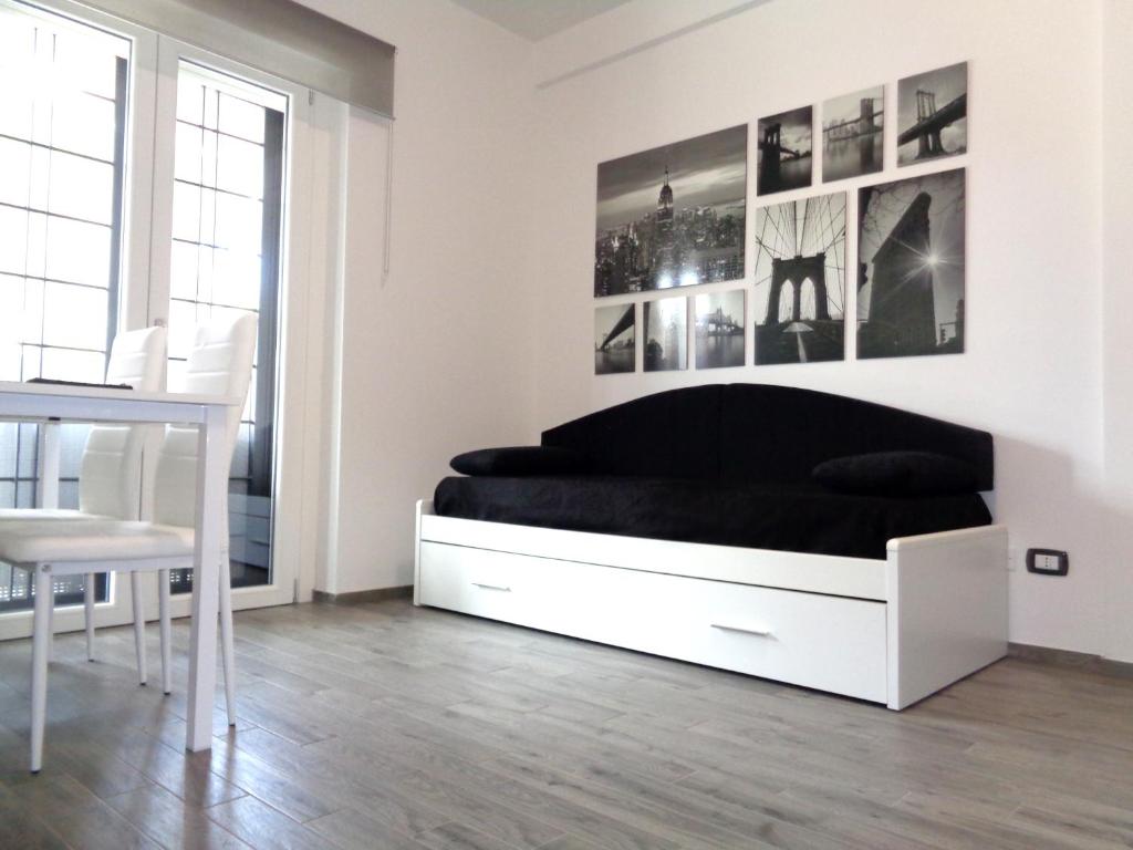 a white bedroom with a black bed and a table at Caput Mundi Anagina IV in Rome