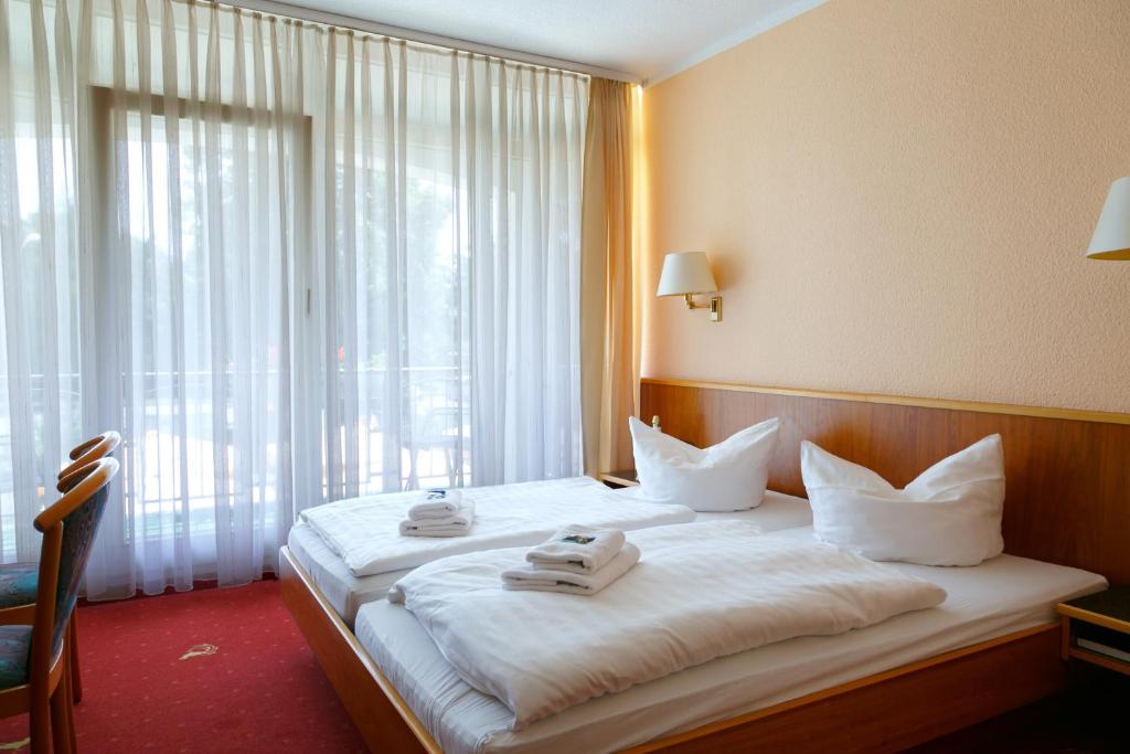 a hotel room with a large bed with towels on it at Hotel Goldener Fasan in Oranienbaum-Wörlitz