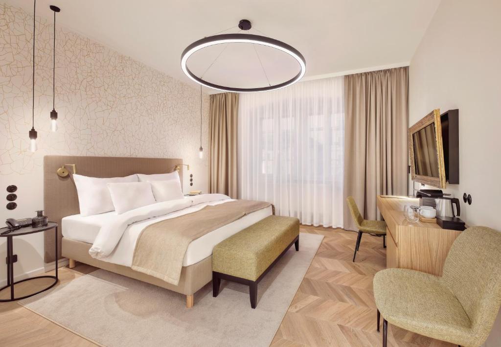 een hotelkamer met een groot bed en een stoel bij Hotel OLDINN in Český Krumlov