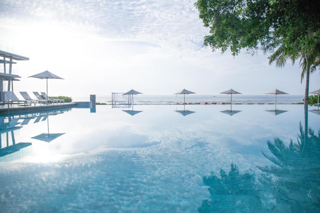 een zwembad met parasols in het water bij Veranda Resort & Villas Hua Hin Cha Am in Cha Am