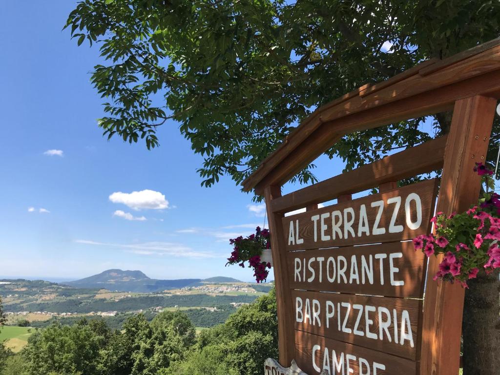 una señal para un restaurante con montañas en el fondo en Locanda "Al Terrazzo", en Erbezzo