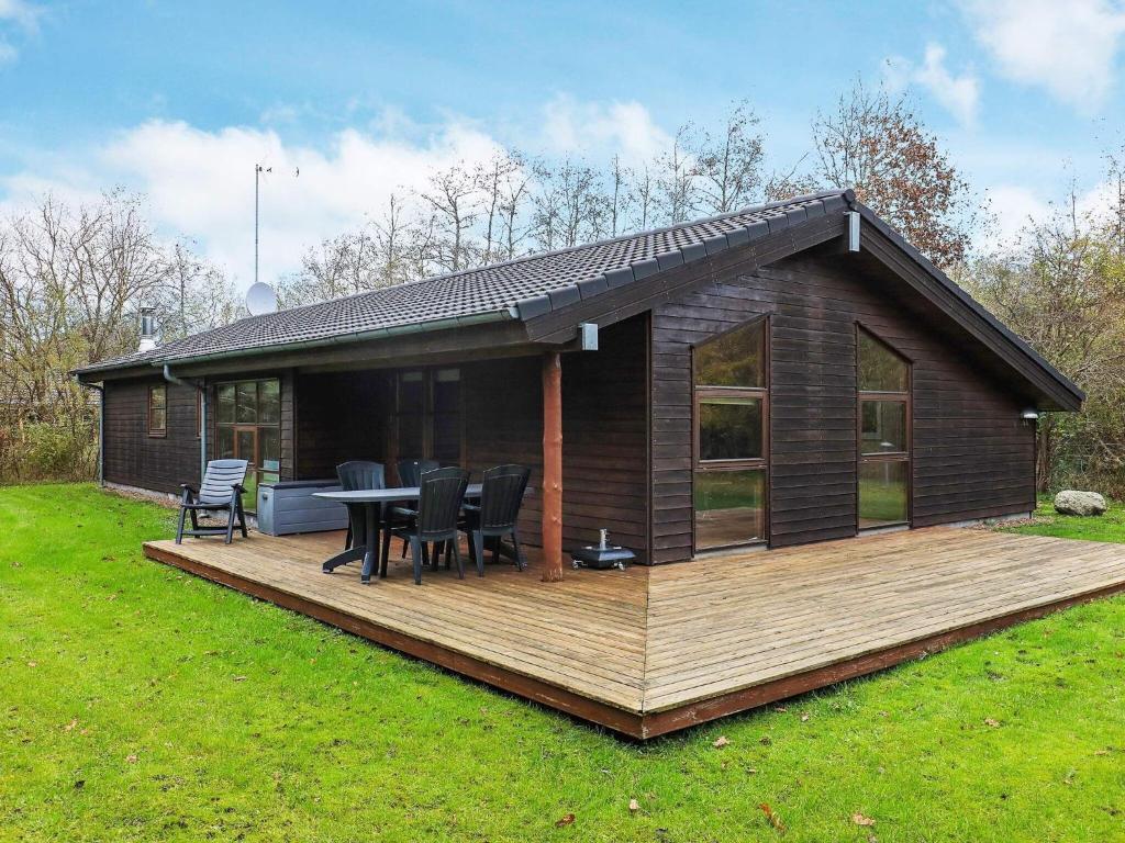 Torup Strandにある8 person holiday home in Fjerritslevの木製デッキとテーブル付きの家