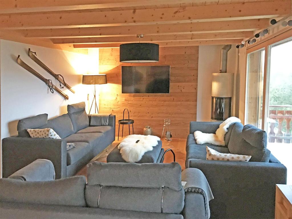 レ・コロンにあるA luxurious 12 person chalet with superb viewのリビングルーム(ソファ2台、テレビ付)