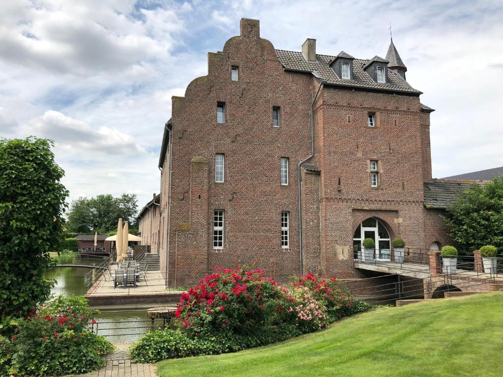 a large red brick building with a bridge at Burg Obbendorf in Niederzier