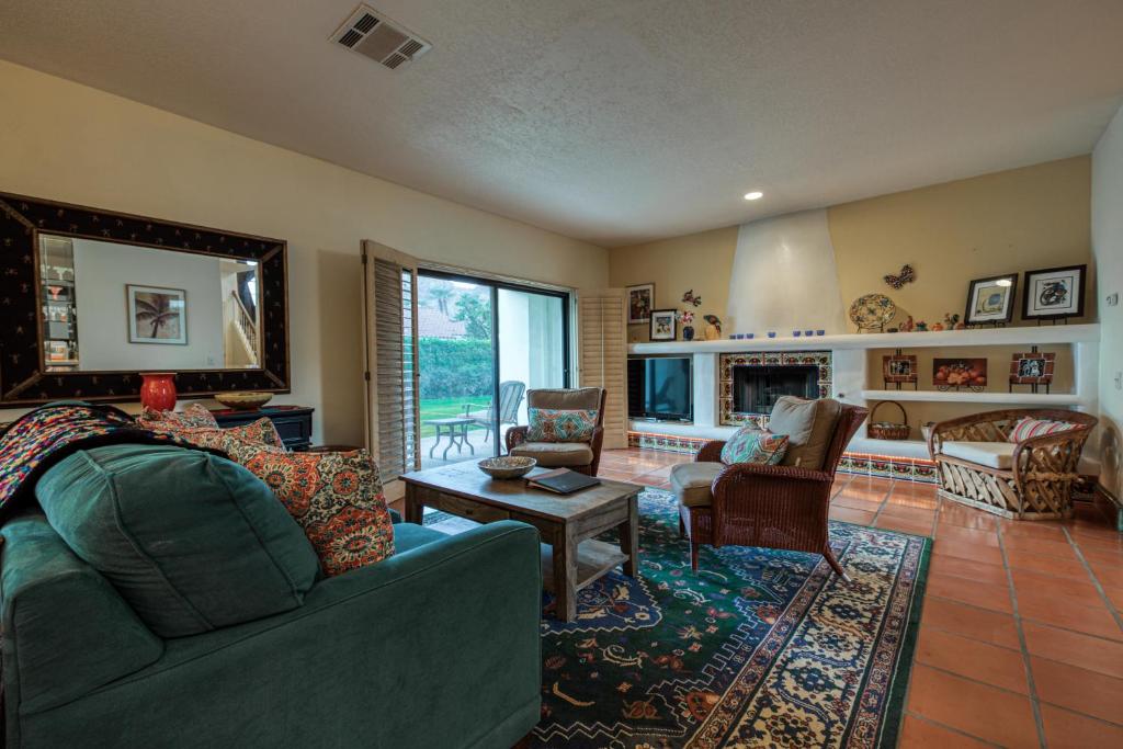 een woonkamer met een bank en een open haard bij Casa La Quinta Permit# 66,014 in La Quinta