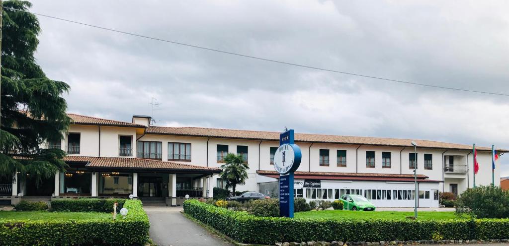 un bâtiment avec une horloge devant lui dans l'établissement Hotel Internazionale Gorizia, à Gorizia