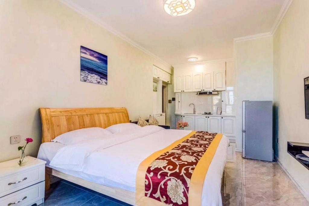 una camera con un grande letto e una cucina di Utopia Apartment a Harbin