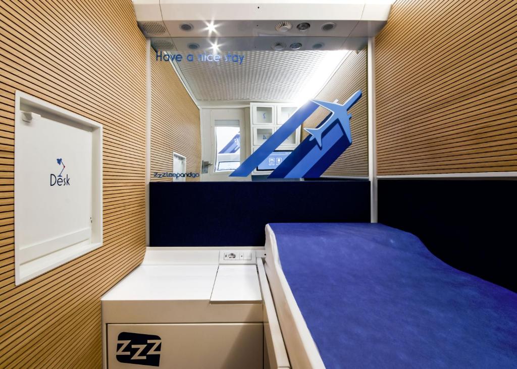 a blue and white room with a blue wall at Resting Pods - ZzzleepandGo VCE Venice Airport in Tessera