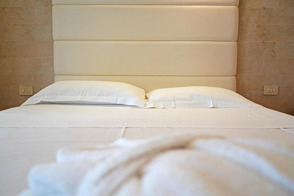 a bed with white sheets and pillows at AmbientHotels Panoramic in Rimini