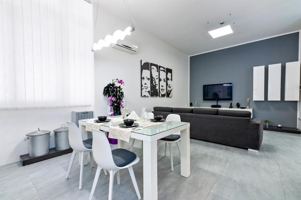 - un salon avec une table et des chaises blanches dans l'établissement MStudio / Loft, à Lecce