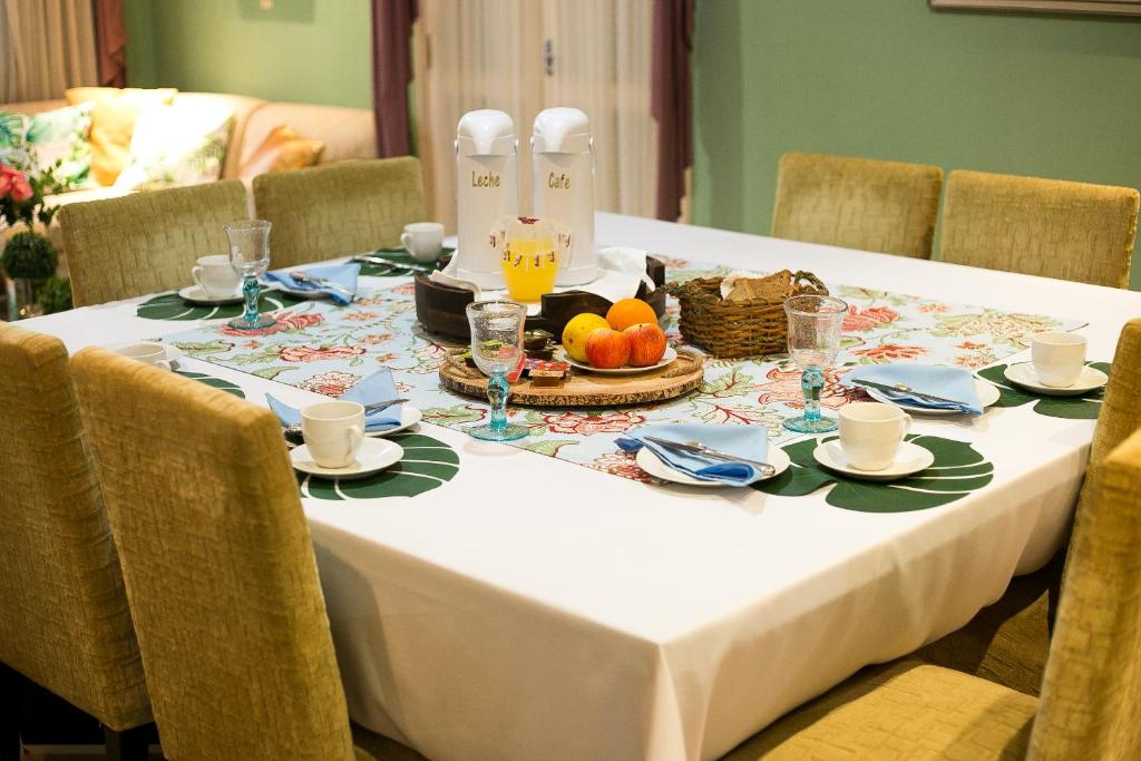 Beulah Hotel Boutique في أسونسيون: طاولة عليها قماش الطاولة البيضاء مع الطعام