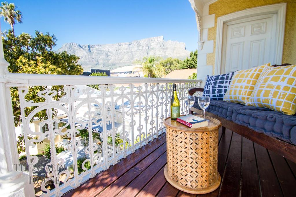a balcony with a couch and a bottle of wine at The Walden House in Cape Town