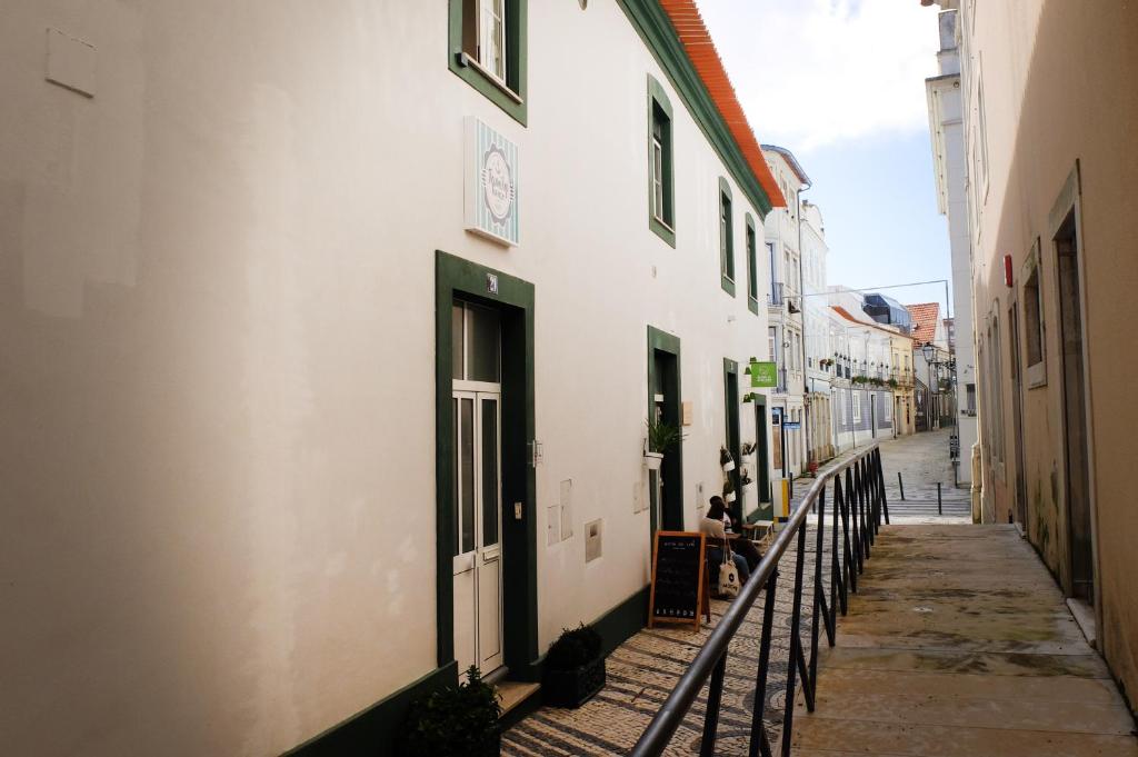 an alley with a white building with a green door at Family House in Aveiro