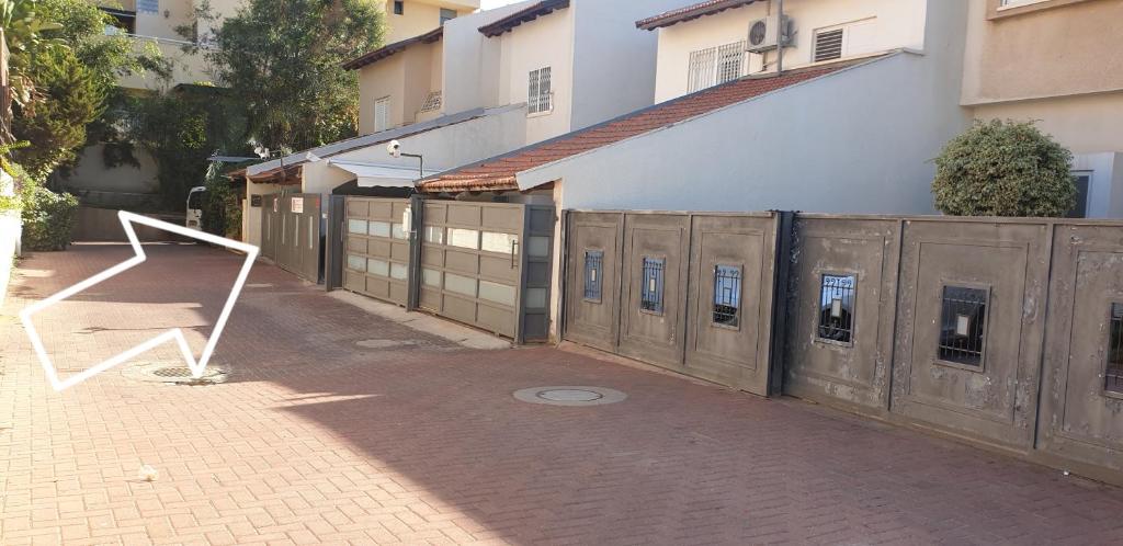 a wooden fence next to a building with windows at Hamedina de Silvina in Kafr Sābā