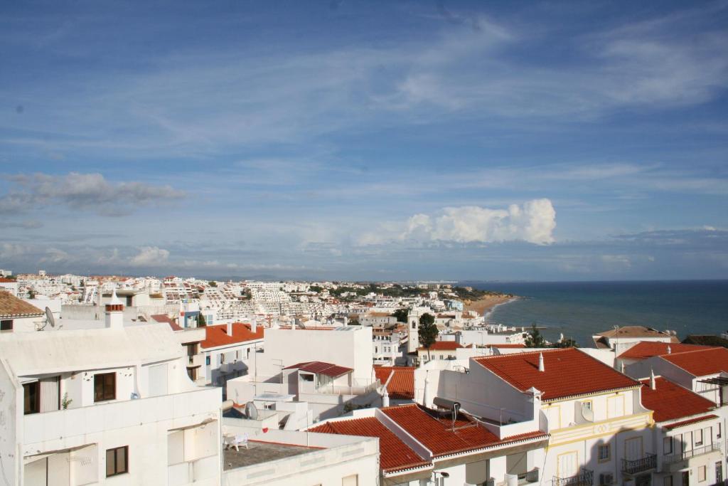 vistas a una ciudad con edificios y al océano en Casa Do Canto, en Albufeira