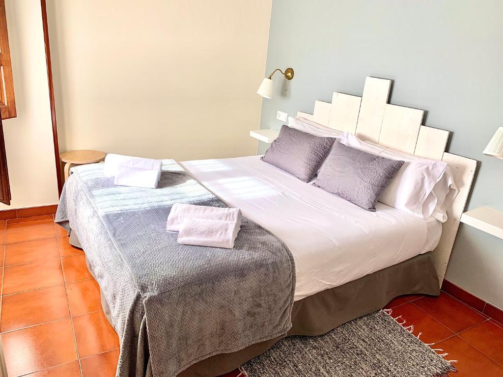 a bedroom with a large bed with two pillows at Hotel Rural Tia Margot in Candelario