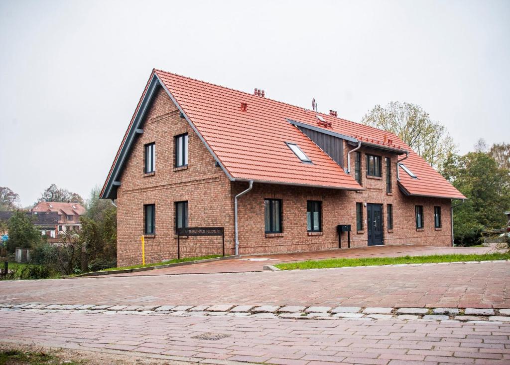 une grande maison en briques avec un toit rouge dans l'établissement Apartmenthaus Feldberg, à Feldberg