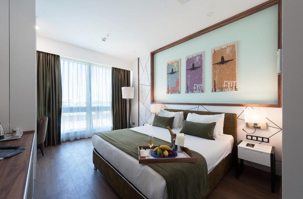 a hotel room with a bed with a tray of fruit on it at ISG Sabiha Gökçen Airport Hotel in Istanbul