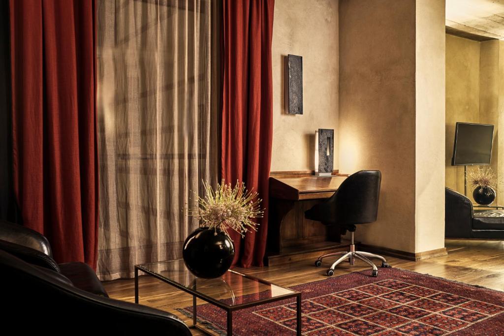 a hotel room with a desk and red curtains at Hotel Stary in Kraków