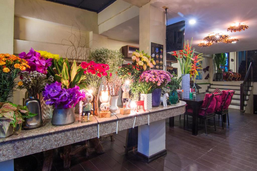 A lobby counter is covered with colorful flower arrangements and vases.