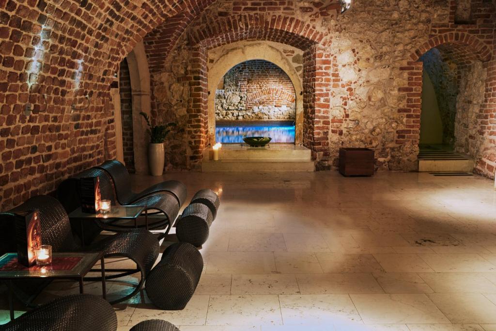 um quarto com uma parede de tijolos e mesas e cadeiras em Hotel Stary em Cracóvia