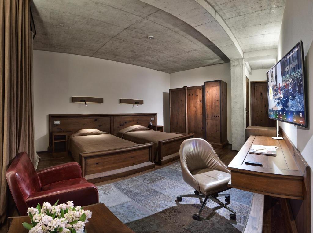 a room with two beds and a desk and a computer at Hotel Stary in Kraków