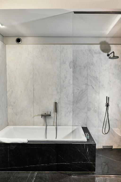 a bath tub in a bathroom with a wall at Hotel Stary in Kraków