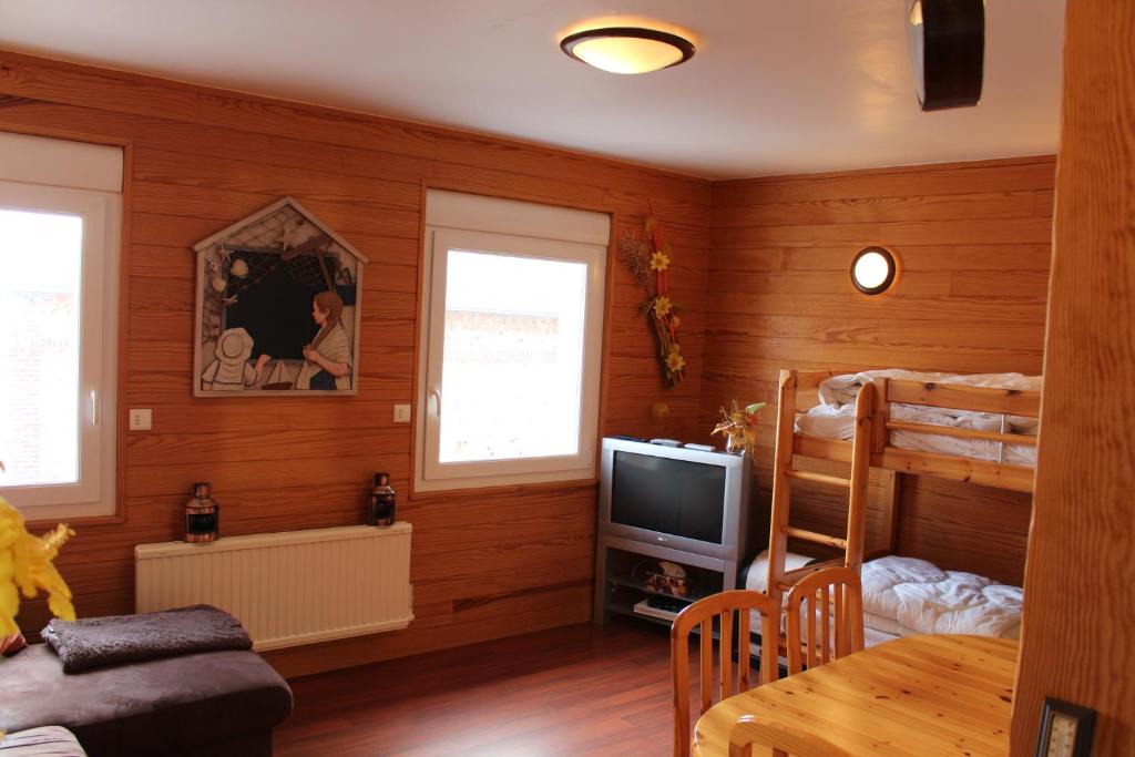 Una habitación con dos literas y un televisor. en Au chalet d'Yport, en Yport