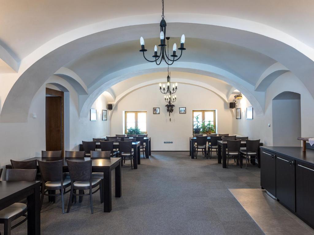 jadalnia ze stołami i krzesłami oraz żyrandolem w obiekcie EA Horský Hotel Hájenka w mieście Modrava