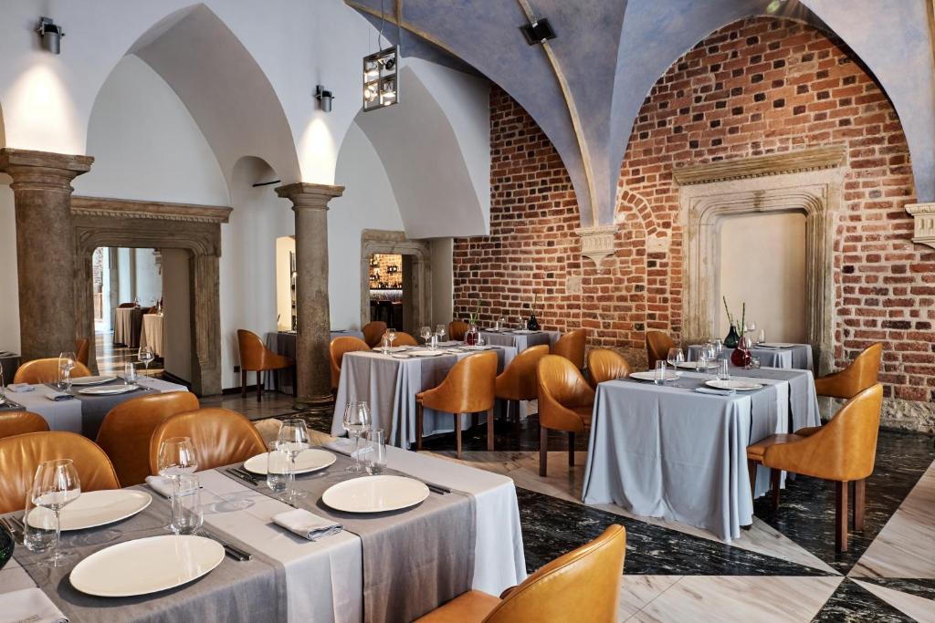 a restaurant with tables and chairs and a brick wall at Hotel Stary in Kraków